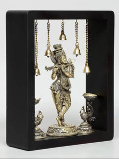 Framed brass Lord Krishna wall hanging with hanging bells and lamp bowls on both sides