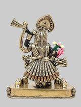 Small brass Krishna statue side view, beaded outfit, halo emblem, raised arm, decorated base