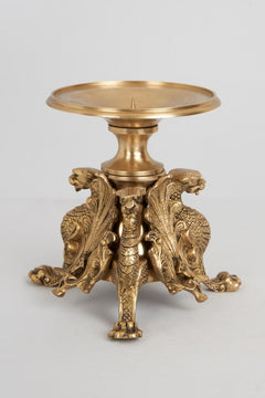 Brass ornate candle stand with split-curled lion reliefs and round top tray