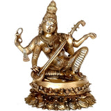 Brass Saraswati idol seated on lotus base, holding veena and symbolic hand tools.
