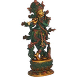 Brass Krishna statue with flute, standing on decorative circular pedestal, green and gold