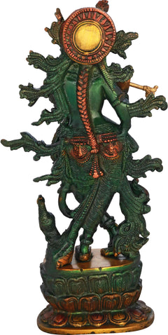 Krishna brass idol from back/side view, flute raised, ornate green figure with halo disc