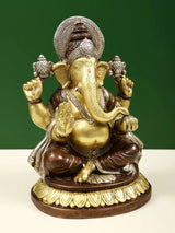 Brass Lord Ganpathi Ganesha statue, close view of face, trunk and raised hands.