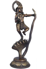 Antique brass Krishna statue holding flute, dancing pose beside cobra hood
