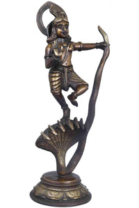 Antique brass Krishna statue holding flute, dancing pose beside cobra hood