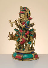 Handcrafted brass Krishna playing flute on cow figurine, multicolor decorative accents