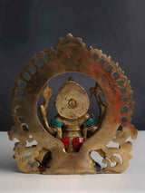 Back view of brass Lord Ganesha with inlay, ornate circular frame, red-blue accents