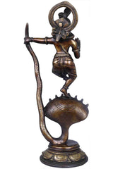 Antique brass Krishna statue from side, lifted foot on cobra with flared hood
