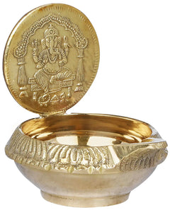 Brass puja diya with seated Ganesha emblem on top and glossy lamp bowl