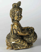 Brass Krishna figure seated with butter pot, ornate headpiece and beaded garlands