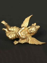Small brass idol of Lord Gandharva in a reclining pose with spread wings and ornate face