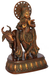 Brass Krishna statue with cow, flute and ornate jewelry, circular halo, 10 inch
