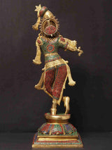 Brass Krishna flute statue with decorative inlay, patterned skirt, standing on base