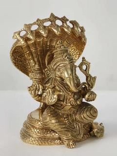Brass Ganesha figurine seated on Sheshnag, three-quarter view with detailed ornaments