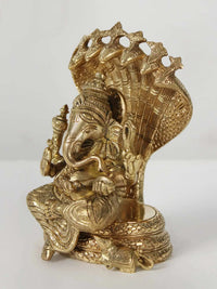 Brass Lord Ganesha statue seated on coiled Sheshnag, side view