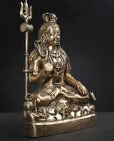 Brass Lord Shiva statue side view, trident raised, detailed face and jewelry ornaments