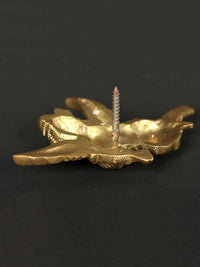 Small brass idol of Lord Gandharva, underside view with staff detail and carved hands