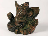 Small Ganesha sculpture showing profile, hand raised and detailed headdress