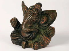 Small Ganesha sculpture showing profile, hand raised and detailed headdress