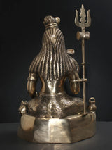 Brass Lord Shiva statue back view with draped robe texture and raised trident