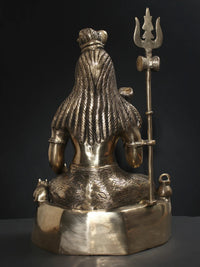 Brass Lord Shiva statue back view with draped robe texture and raised trident