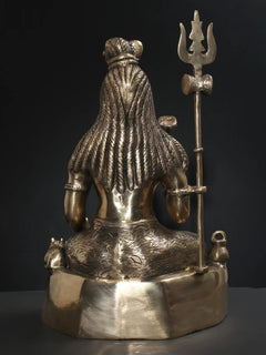 Brass Lord Shiva statue back view with draped robe texture and raised trident