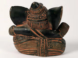 Small Ganesha sculpture from side, seated pose with patterned clothing