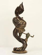Brass Krishna idol side view, peacock tail above head; flute in hands