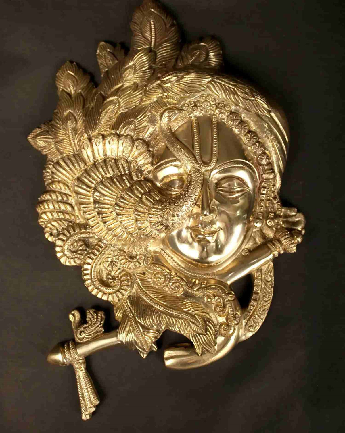 Brass Wall Hanging of Krishna’s fluted face with ornate crown and raised flute