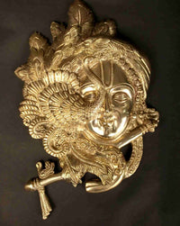 Brass Wall Hanging of Krishna’s fluted face with ornate crown and raised flute