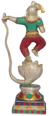 Dancing brass Shri Krishna statue, turquoise top, red patterned pants, coiled serpent