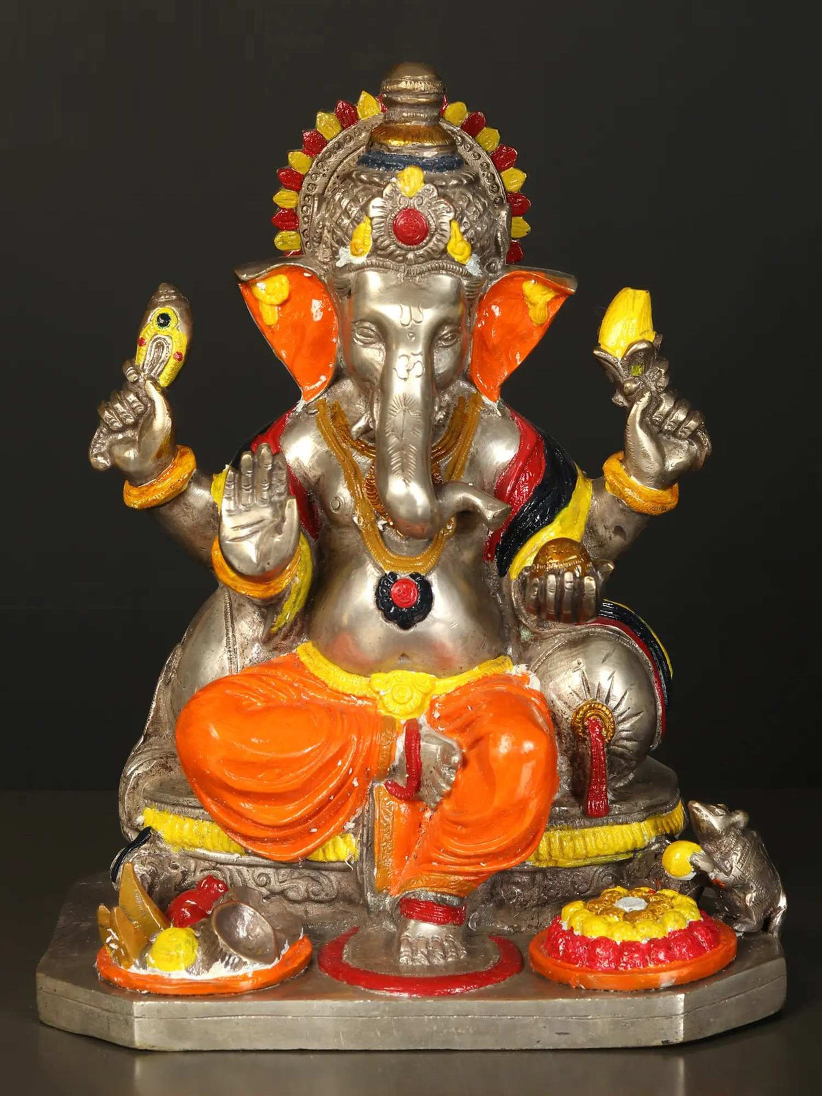 Brass Lord Ganesha figurine wearing orange dhoti, seated on a base with accessories