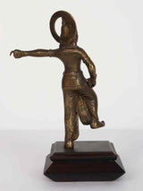 Brass Lord Krishna statue with arms out, draped garment, on dark wooden pedestal