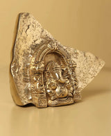 Natural brass Ganesha temple idol from rock, front view with ornate relief panel