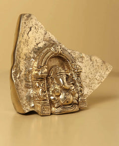 Natural brass Ganesha temple idol from rock, front view with ornate relief panel