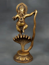 Brass dancing Lord Ganesha statue on Sheshnaag base, raised arms, ornate jewelry