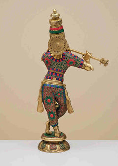 Brass Krishna fluting statue from behind, patterned dhoti and large circular back ornament
