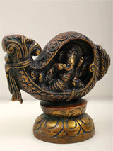 Brass Ganesha figurine holding shankha, ornate swirl patterns and gold accents