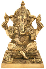 Brass Ganesha statue seated cross-legged on ornate square pedestal, four arms raised