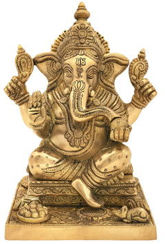 Brass Ganesha statue seated cross-legged on ornate square pedestal, four arms raised