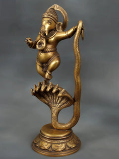 Brass dancing Lord Ganesha figure, one hand raised, on coiled Sheshnaag with fan base