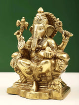 Brass Ganpati statue side view, four arms holding attributes, ornate drapery, 5 in