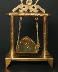 Brass jhoola with arched seat panel, deity peacock-sun top, hanging chains