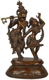 Brass statue of Radha and Krishna dancing, Krishna holds flute, raised arms.