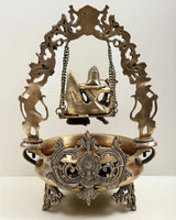 Brass urli back view, carved swing arch with Radha Krishna figures and chains