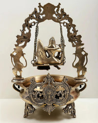 Brass urli back view, carved swing arch with Radha Krishna figures and chains
