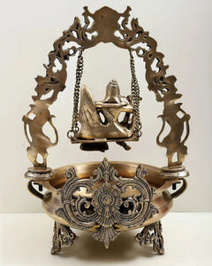 Brass urli back view, carved swing arch with Radha Krishna figures and chains