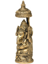 Small brass Ganesha idol with carved umbrella, 5 inches, side view, seated base