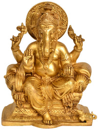 Brass Lord Ganesha seated on throne, hands raised, ornate headpiece and jewelry