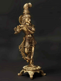 Standing brass Krishna statue holding flute, ornate crown and jewelry, on base